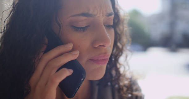istock Closeup of young hispanic woman drinking while talking on a cell phone. 1095072042