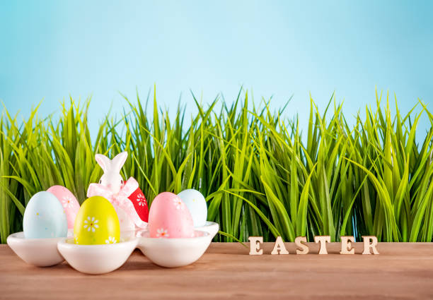 istock Easter eggs and cute bunny on wood table with green grass. Festive decoration 1095074656