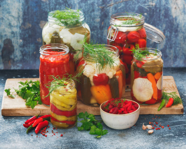 conservas y encurtidos en conserva frascos sobre la mesa rústica - preserves pickle jar relish fotografías e imágenes de stock