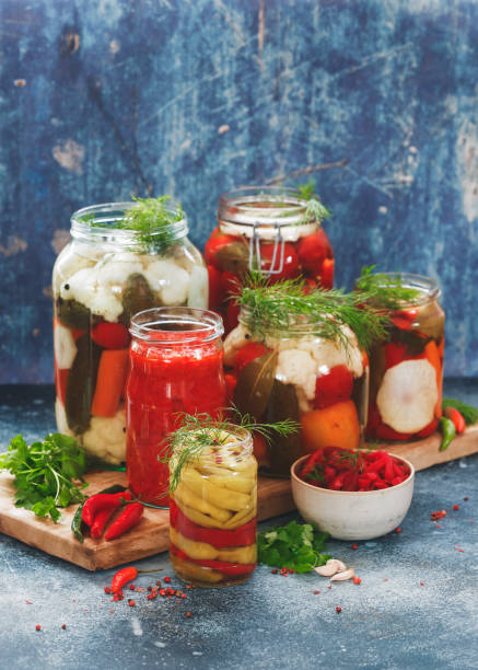 hausgemachte essiggurken an verschiedenen gemüse in gläsern - preserves pickle jar relish stock-fotos und bilder