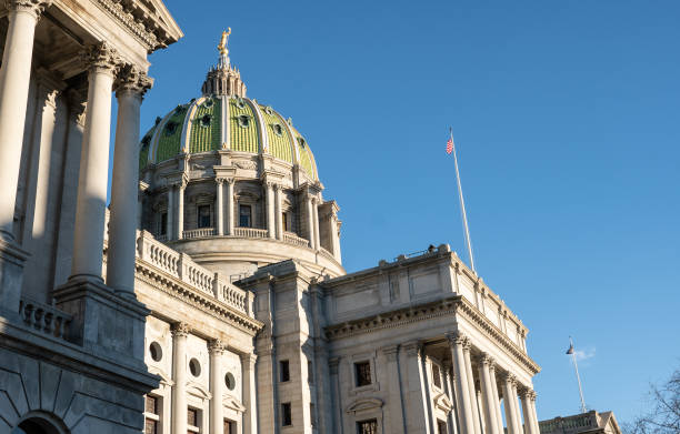 Harrisburg, Pennsylvania, Capitol building Capitol building, Harrisburg, Pennsylvania with American flag flying against a blue sky. harrisburg pennsylvania stock pictures, royalty-free photos & images