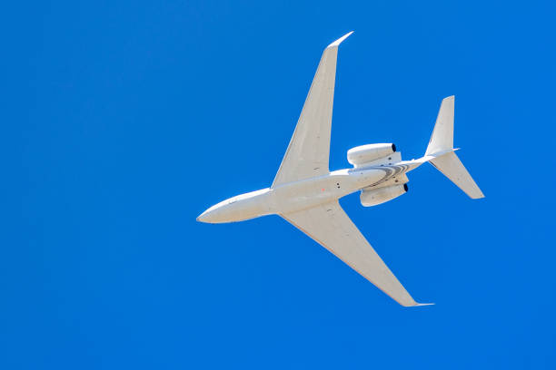 istock Looking up at a low flying airplane; blue sky background 1095086566