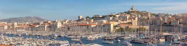 Panoramic view over the harbor and city of Marseille on the southern coast of France. On top of the hill is the iconic Notre Dame de la Garde basilica.