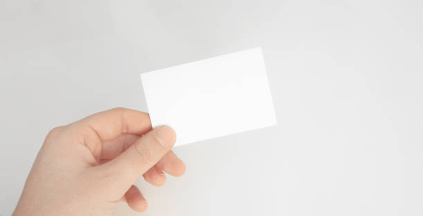 istock Person hand holding blank paper card isolated white background 1095100686