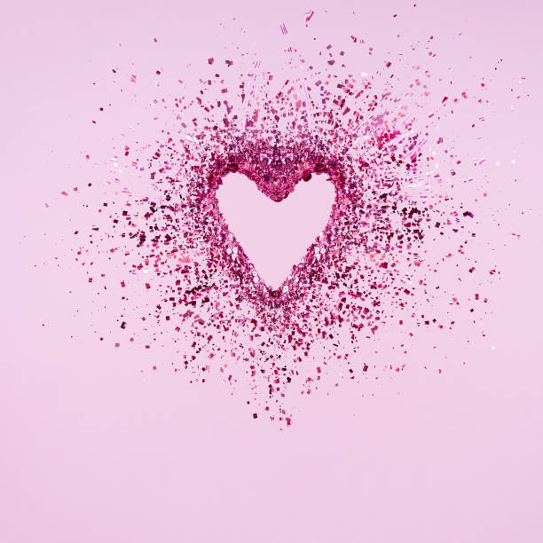 istock Glitter heart dissolving into pieces on pink background.  Valentines day, broken heart and love emergence concept 1095101028