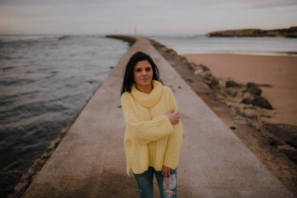 istock Woman sitting by a beach 1095112536