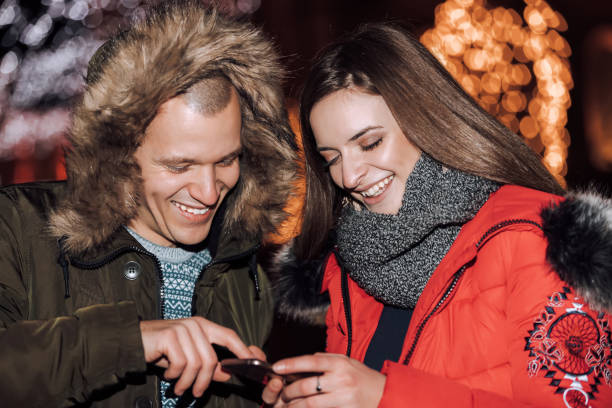 istock Young happy couple using smartphone  at night 1095118182