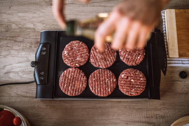 istock Chef Spicing Juicy Hamburgers 1095131570