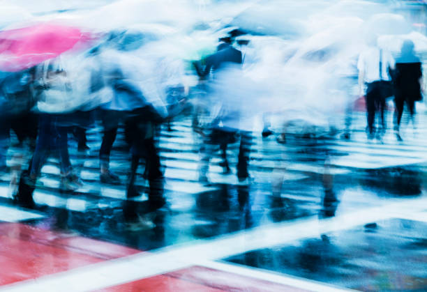 city commuters at crosswalk on a rainy morning