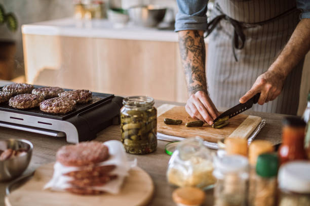 istock Male Chef Chopping Pickles While Baking Burgers 1095137734