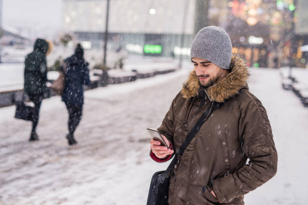 istock Young man texting a message on a snowy day in the city. 1095141018