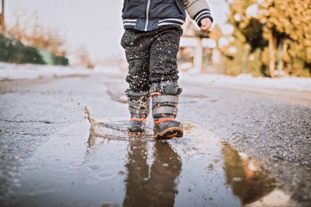 istock Baby boy running happily through puddles 1095149930