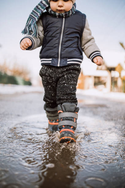 istock Baby boy running happily through puddles 1095149938
