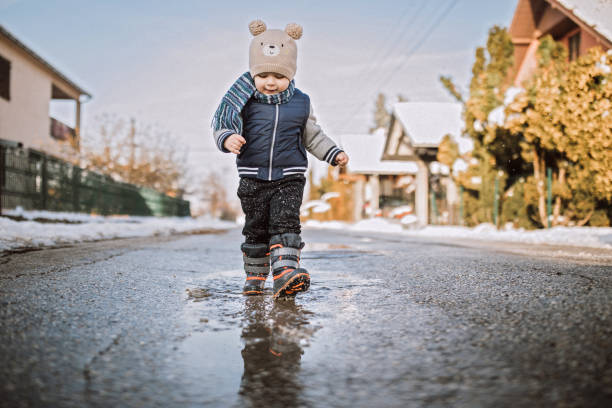 istock Baby boy running happily through puddles 1095150004