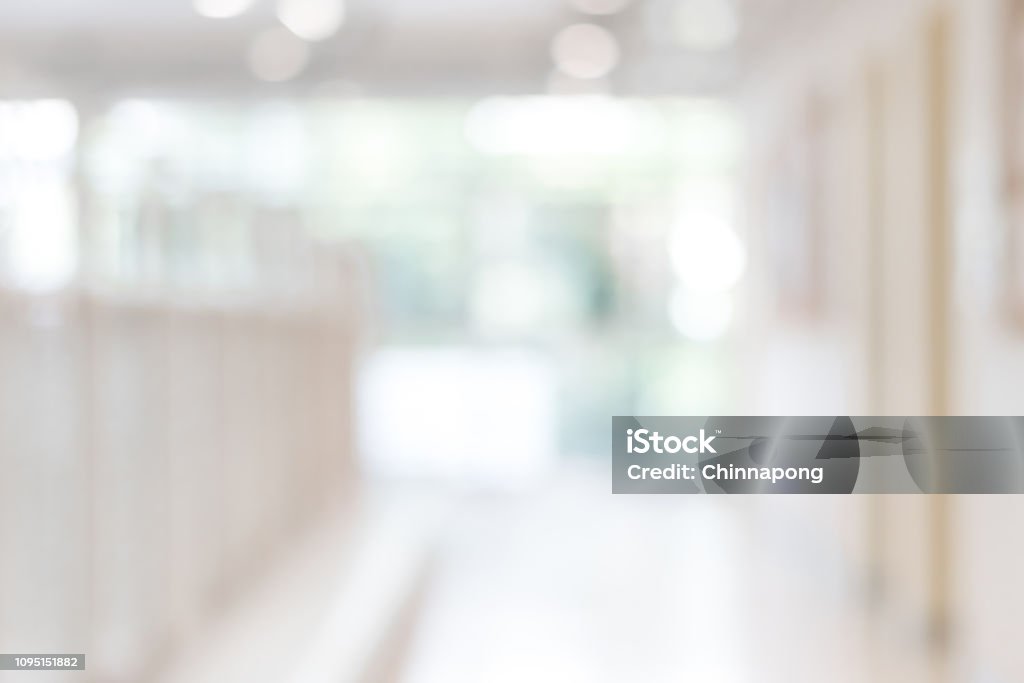 Corridor in school or office building blur background with blurry interior view empty hall way, glass curtain wall and floor with exterior light illumination Backgrounds Stock Photo