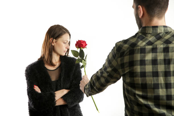 Retrato De Una Joven Pareja Tiene Conflictos Hombre Pidiendo Perdón Con Una Flor Rosa Roja A Su Novia Ofendida Estudio Tiro Aislada En Blanco Foto de stock y más banco de imágenes Retrato De Una Joven Pareja Tiene Conflictos Hombre Pidiendo Perdón Con Una Flor Rosa Roja A Su Novia Ofendida Estudio Tiro Aislada En Blanco Foto de stock y más banco de imágenes
