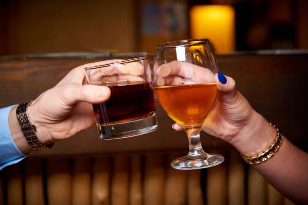 istock Clinking glasses in hands on blurred dark background. 1095169032