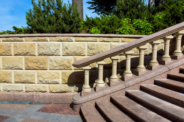 istock Baroque staircase with marble steps and stone balustrades under the railing on the background of a wall of stone tiles and plants in the background. 1095170078