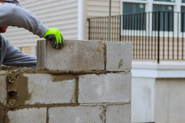 istock masonry worker make concrete wall by cement block and plaster at construction site 1095172584