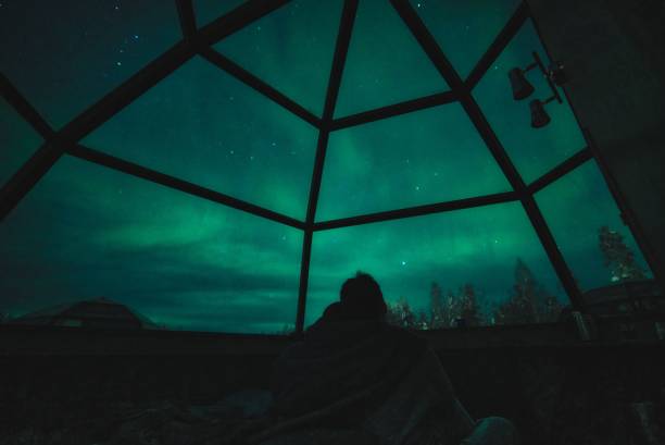 ein paar genießen sie blick auf aurora borealis und sterne im glas-iglu in lappland, rovaniemi, finnland - aurora borealis aurora polaris lapland finland stock-fotos und bilder