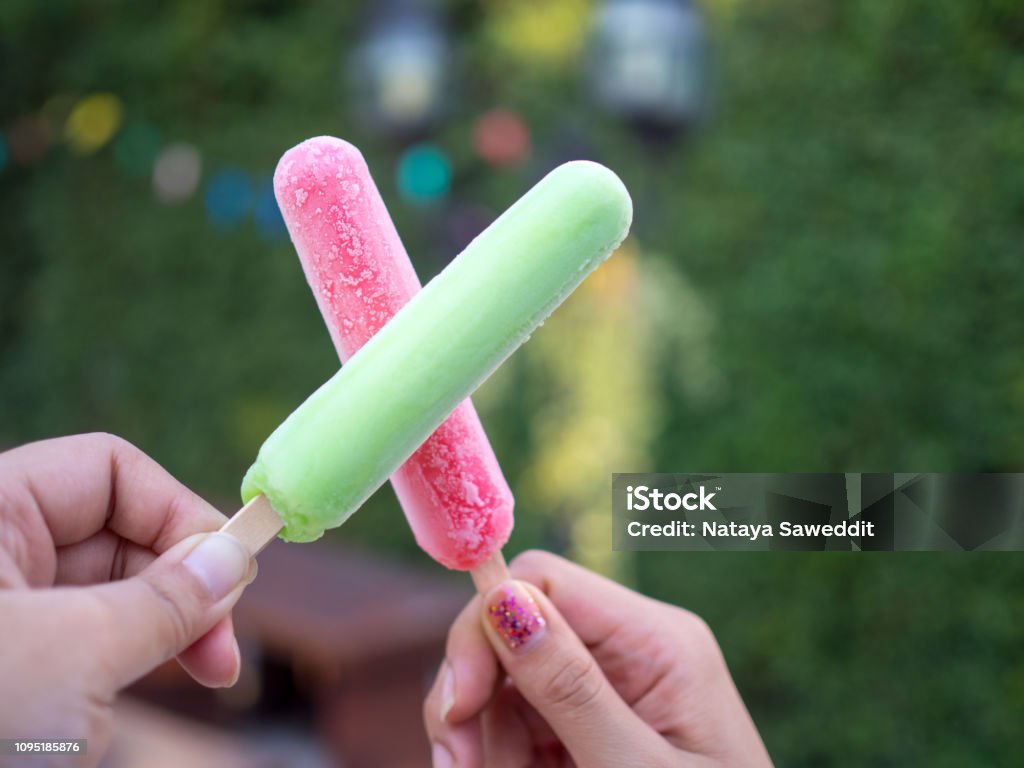 Hand Holding Green And Red Popsicle Sticks Overlapping Green Background  Stock Photo - Download Image Now - iStock