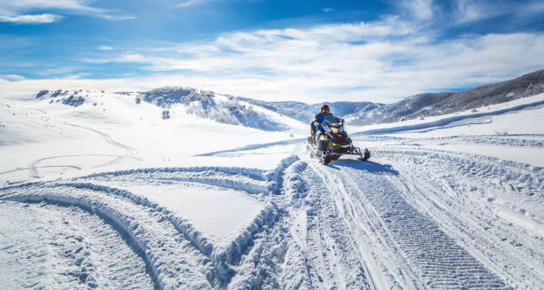 conducir una moto de nieve - motoesquí fotografías e imágenes de stock