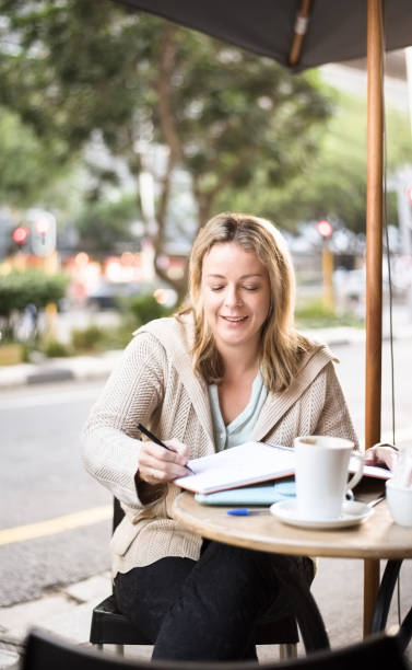 istock Woman sitting outside at a table at a sidewalk cafe 1095193816