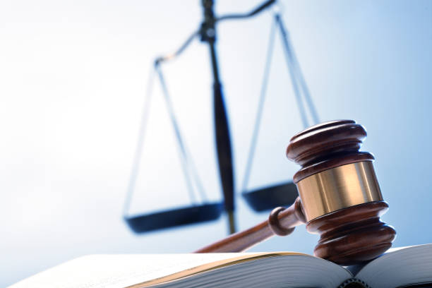 istock Gavel On Open Law Book With Justice Scale In The Background 1095196258