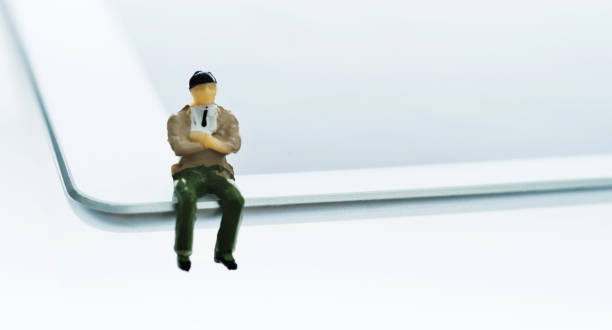 istock Businessman figurine sitting on digital tablet 1095202140