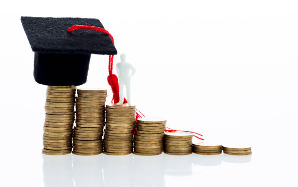 istock Graduation hat and figurine on coins 1095202152