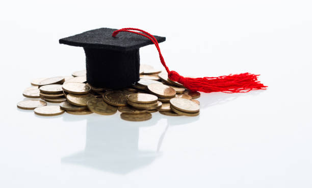 istock Graduation hat and heap of coins 1095202158