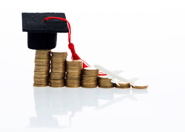 istock Graduation hat and plane toy on coins 1095202160