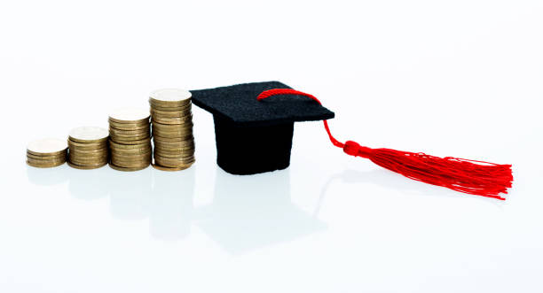 istock Graduation hat and heap of coins 1095202198