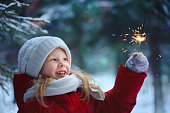 Little girl with bengal lights. Winter, day.