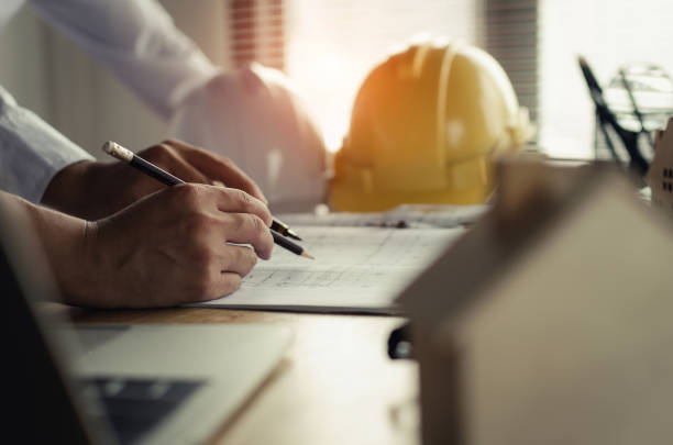 istock professional team of architect, engineer or interior hands drawing with blueprint on workplace desk in office center at construction site, contractor, construction, engineering and business concept 1095206316