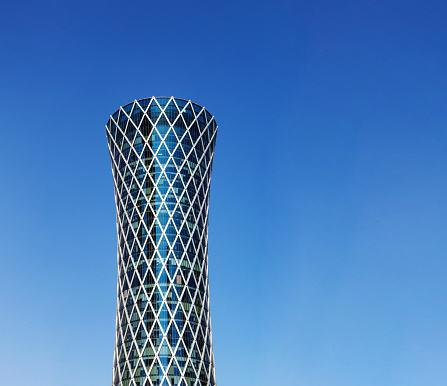 Financial success concept. Modern skyscraper on blue background with copy space (Qipco Tower, Tornado Tower)