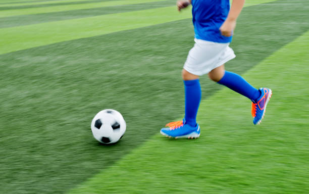 istock Young boy running after a soccer ball 1095227180