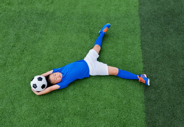 istock Young boy lying on soccer field 1095227266