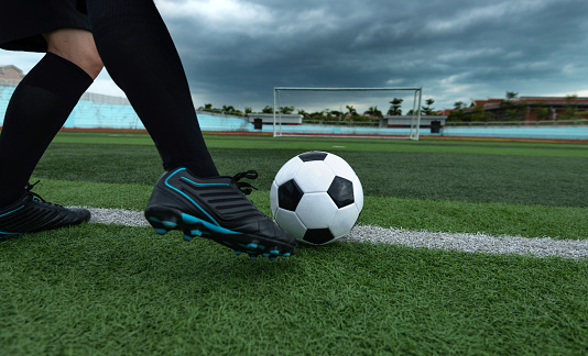 Soccer player foot kicking soccer ball