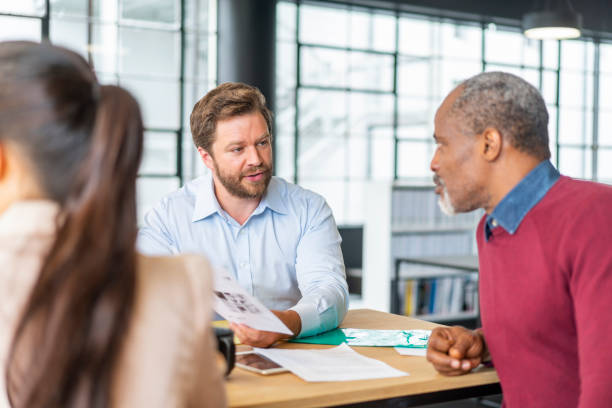 istock Male colleagues discussing over document at office 1095237764