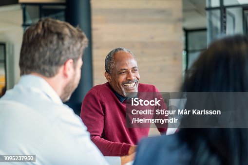 istock Happy mature male manager sitting with colleagues 1095237950