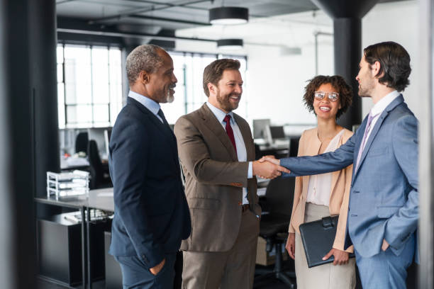 istock Businessmen greeting while standing by colleagues 1095240178