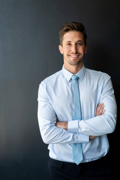 istock Businessman standing arms crossed against wall 1095241126