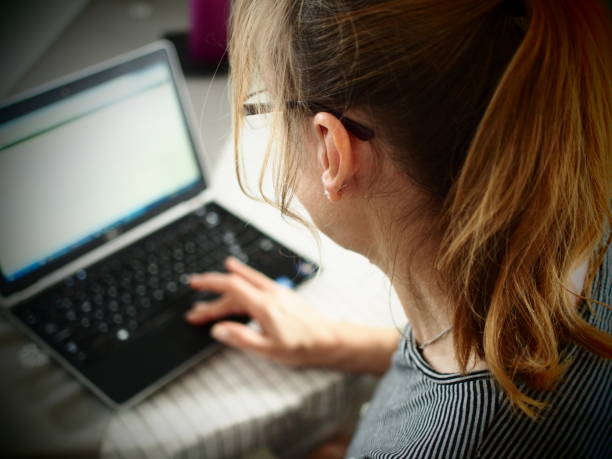 istock Middle-aged woman using laptop at home 1095247582