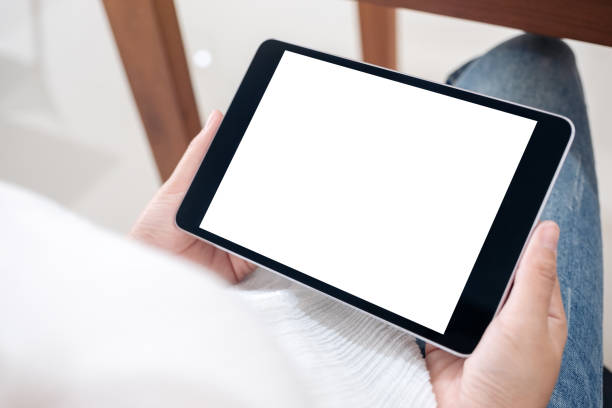 istock Mockup image of a woman holding black tablet pc with blank white screen horizontally while sitting in cafe 1095248682