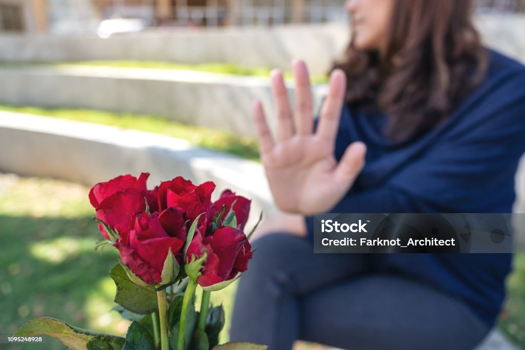 Una mujer rechaza una flor rosas de alguien el día de San Valentín - Foto de stock de Hombres libre de derechos