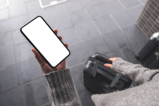 istock Top view mockup image of a woman holding black mobile phone with blank desktop screen while while holding a baggage 1095248954