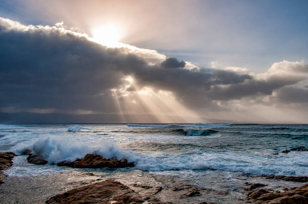 the sun's rays cross the clouds and illuminate the sea on the Corsican coast