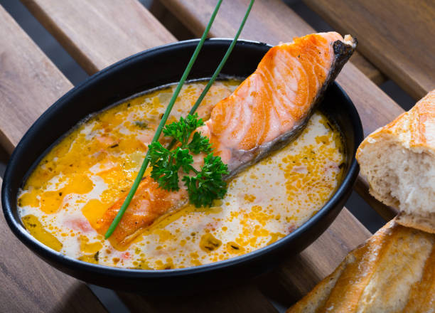 istock Delicious cream  soup with salmon, served  in bowl with bread at table 1095273324