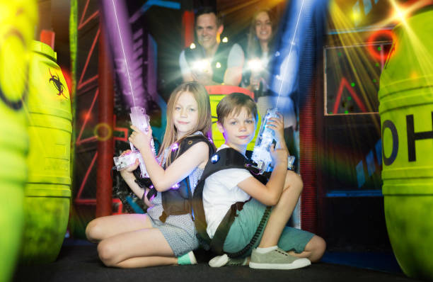 istock Kids sitting back to back with laser guns in beams 1095277356